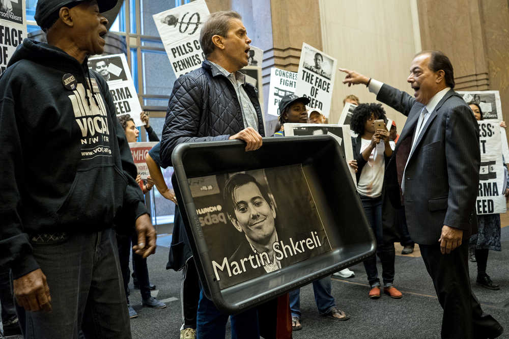 FILE - In this Thursday, Oct. 1, 2015, file photo, carrying an image of Turing Pharmaceuticals CEO Martin Shkreli in a makeshift cat litter pan, AIDS activists and others are asked to leave the lobby during a protest highlighting pharmaceutical drug pricing. The same strategy that Shkreli used to get away with a 5,000-percent price increase on an old drug is used by many other drugmakers to maintain sky-high prices on billions of dollars' worth of medications. Shkreli, who resigned from Turing Pharmaceuticals in December 2015, was arrested and has pleaded not guilty to securities fraud and conspiracy charges. (AP Photo/Craig Ruttle, File)