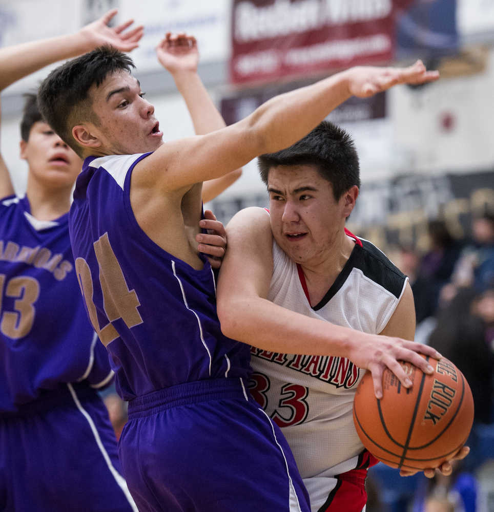 Klawock's Mike Kennedy, right, runs into the defensive coverage of Hydaburg's Nick Nix, center, and Michael Eaglestaff, left, in the 1A Region V Basketball Championship game at Thunder Mountain High School on Friday. Hydaburg won 34-29.