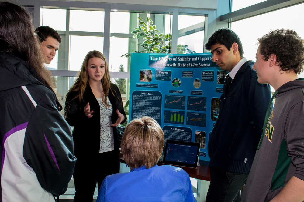 Aakash Bathija, Katrina Buchanan and Brian Holst get an opportunity to educate acting Mayor Mary E. Becker about their research into "The Effects of Salinity and Copper on the growth rate of Ulva lactuca."