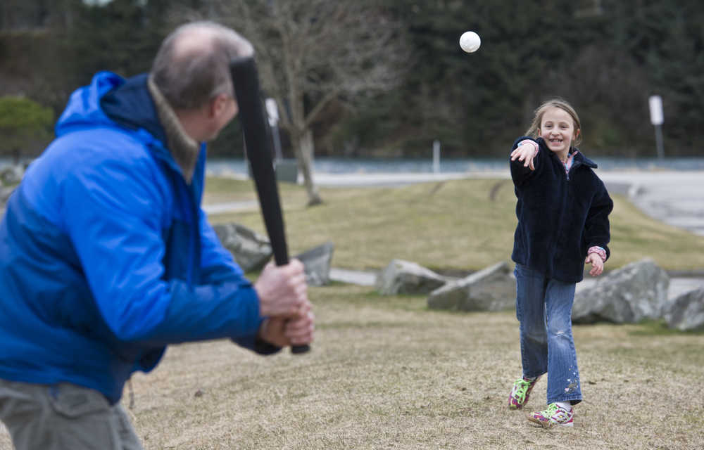 Canyon Simanis, 8, pitches to her father, Erik, at Savikko Park on Tuesday. The family from Whitehorse, Yukon, is visiting during their spring break.