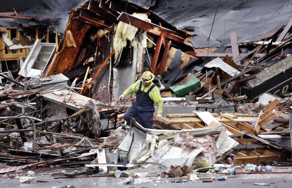 A worker walks in the rubble left from an early morning explosion Wednesday, March 9, 2016, in Seattle. The natural gas explosion sent multiple firefighters to the hospital and reduced several businesses to rubble. (AP Photo/Elaine Thompson)
