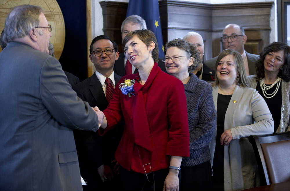 Rep. Ivy Spohnholz, D-Anchorage, center, is congratulated by Speaker of the House Mike Chenault after her official swearing-in to her House seat at the Capitol on Thursday. Along with other representatives watching the event is Spohnholz's mother, Ann, who was appointed to the House by Gov. Steve Cowper in 1989.