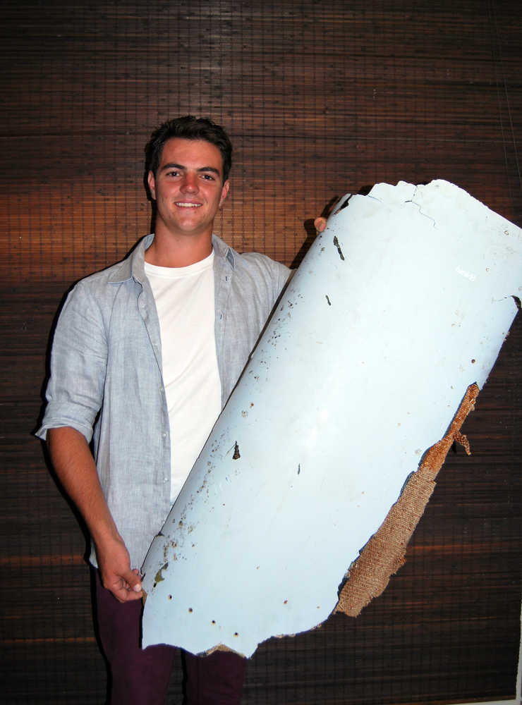 Liam Lotter poses with a piece of debris thought to be part of the missing Malaysia Airlines Flight MH370, in Wartburg, 37km (22 miles) out of Pietermaritzburg, South Africa, Friday, March 11, 2016.  South African teenager Liam Lotter vacationing with his family in Mozambique on Dec. 30, may have found part of a wing from the missing plane, while he was strolling on the beach. Liam struggled to lift the debris from the beach and carried it back home to South Africa before discovering it might be from the lost plane, but now aviation experts plan to examine the plane fragment. The Malaysia Airlines Boeing 777 jet vanished with 239 people on board while flying from Kuala Lumpur to Beijing on March 8, 2014.  (Candace Lotter via AP)