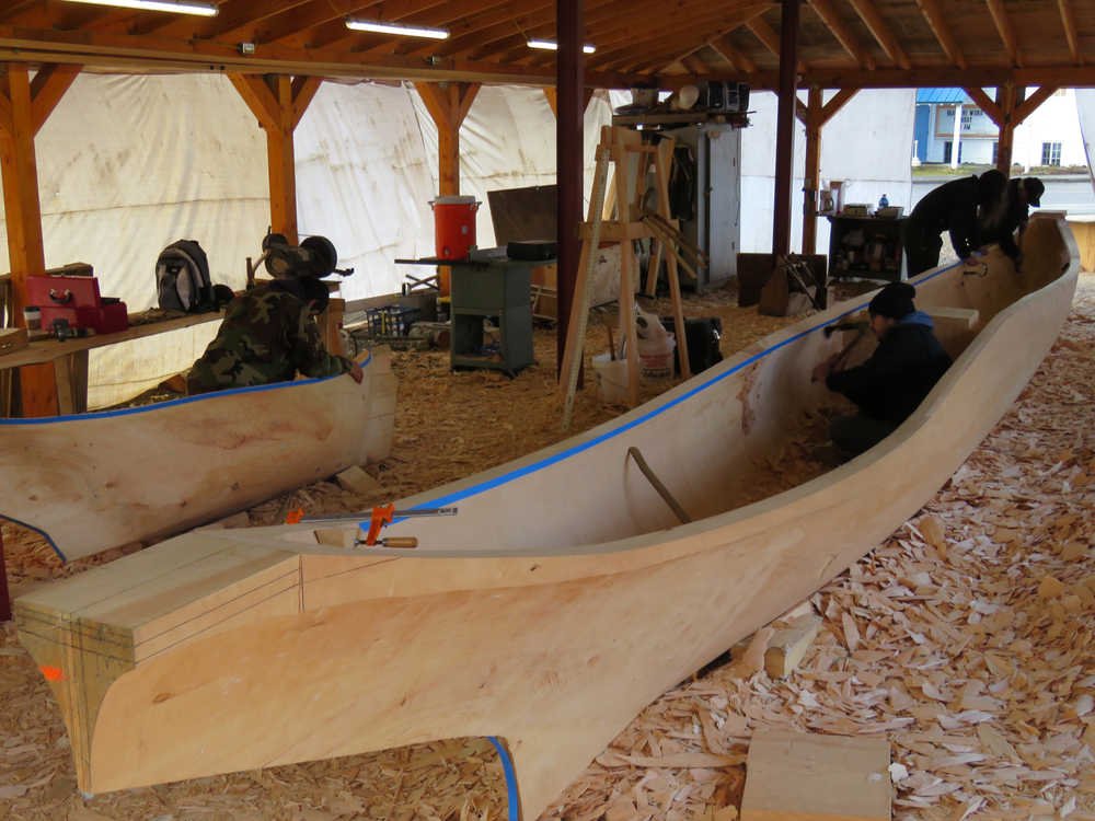 At left, Steven Price works on a small dugout to be displayed in Skagway, while carvers James (Gooch Éesh) Hart, Zack (Tlél Tooch Tláa.aa) James, and Wayne Price work on the first of two 40-foot spruce dugout canoes. All three apprentice carvers are volunteering their time, working ten hours a day, seven days a week for about nine months.