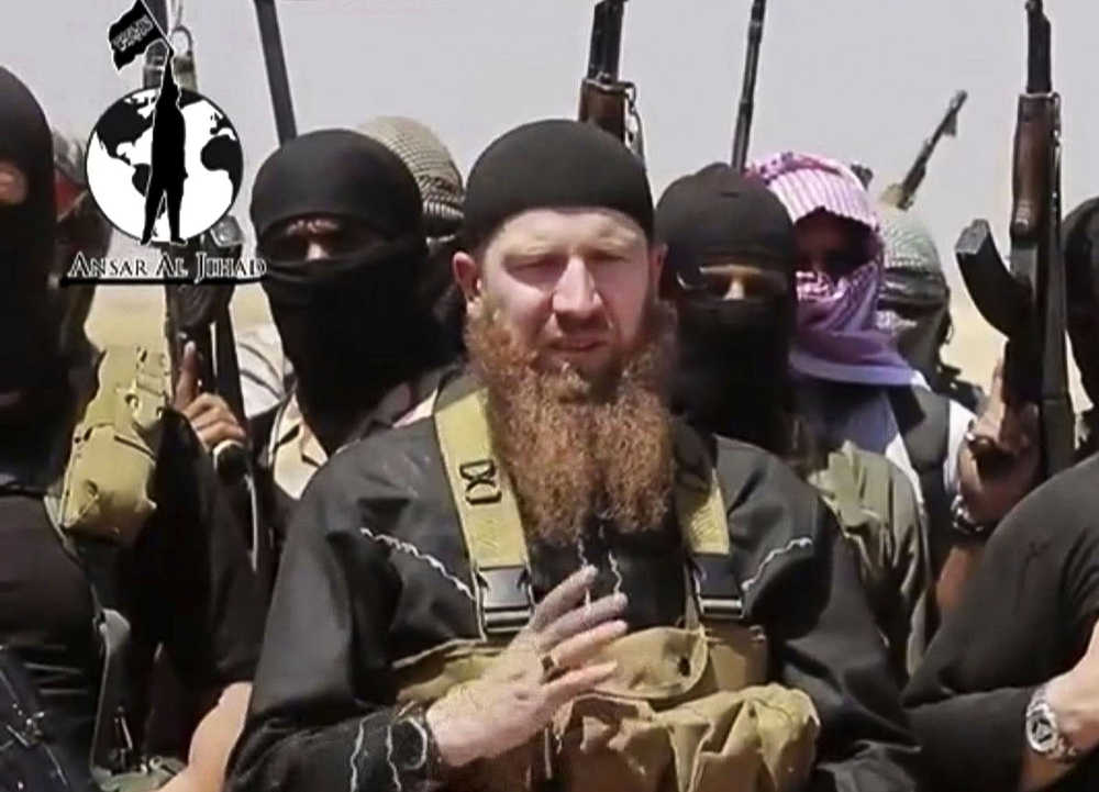 FILE - This image made from undated video posted during the weekend of June 28, 2014 on a social media account frequently used for communications by the Islamic State of Iraq and the Levant (ISIL), which has been verified and is consistent with other AP reporting, shows Omar al-Shishani standing next to the group's spokesman among a group of fighters as they declare the elimination of the border between Iraq and Syria. An Iraqi official and a Syrian activist say senior Islamic State group leader Al-Shishani died Monday, March 15, 2016 outside Raqqa, Syria. Shishani was injured in a U.S. airstrikes last week and subsequently died from his wounds, the senior Iraqi intelligence official and Rami Abdurrahman, of the Britain-based Syrian Observatory for Human Rights told the Associated Press. (AP Photo/militant social media account via AP video)