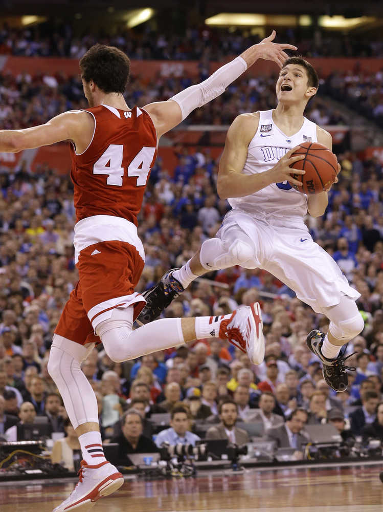 In this April 6, 2015 photo, Duke's Grayson Allen drives to the basket as Wisconsin's Frank Kaminsky defends during the championship game of the NCAA men's tournament in Indianapolis. Coach Mike Krzyzewski went with a hunch and called on Allen, who, at the time, was an overshadowed freshman averaging four points a game.  Allen made a 3-pointer to start Duke's comeback and screamed "Let's Go,'' in an attempt to bring his team back to life. He finished with 16 points and became the focal point of a comeback for a team filled with NBA talent.