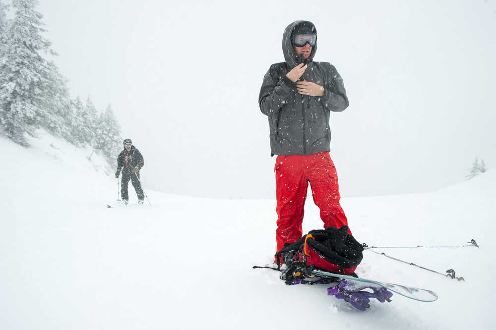 Snowboarder Derek Eby, right, takes a break from hiking to the top of the Eaglecrest Ski Area as skier John Wilcock skins up on Wednesday.