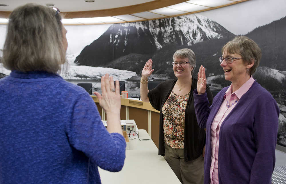 Juneau Municipal Clerk Laurie Sica, left, swears in City Manager Kim Kiefer, center, and Assistant City Manager Mila Cosgrove to be election workers so they could help count questioned ballots from Tuesday's special mayoral election in the Assembly Chamber on Friday.
