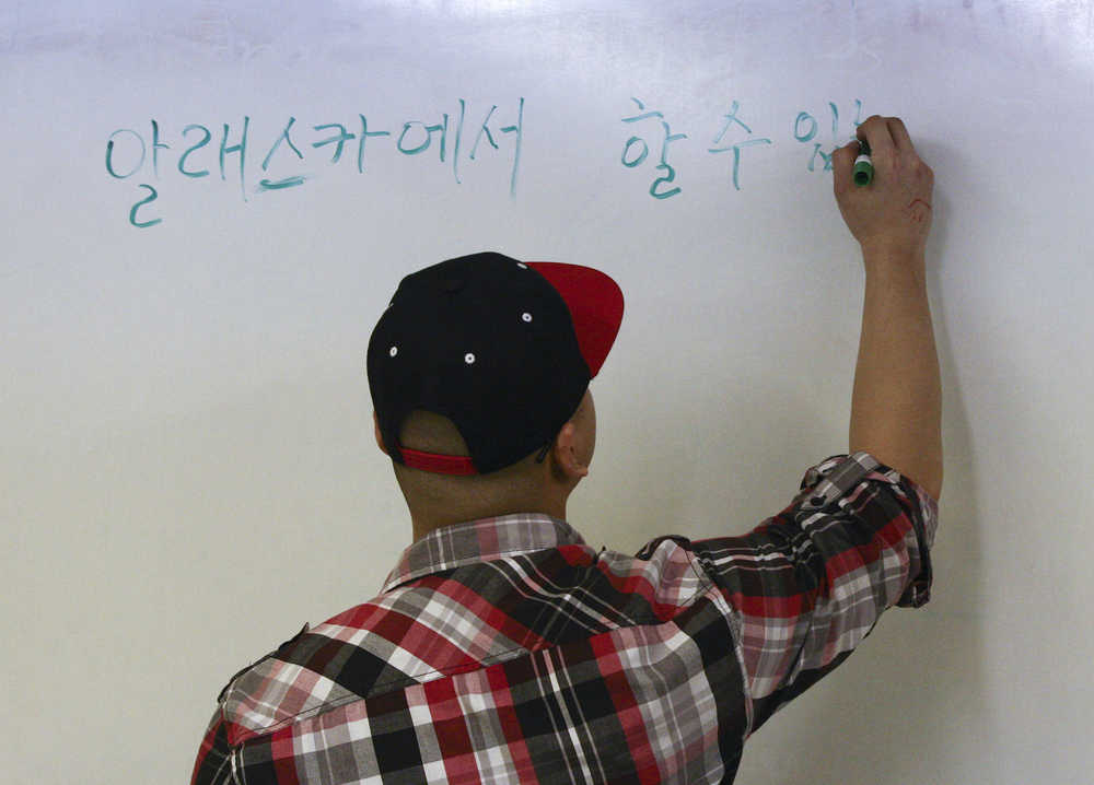 In this March 5 photo, Danny Kim, a teacher at the Fairbanks Korean Language School, begins to write, "things you can do in Alaska," on the whiteboard in Korean at the school in Fairbanks.