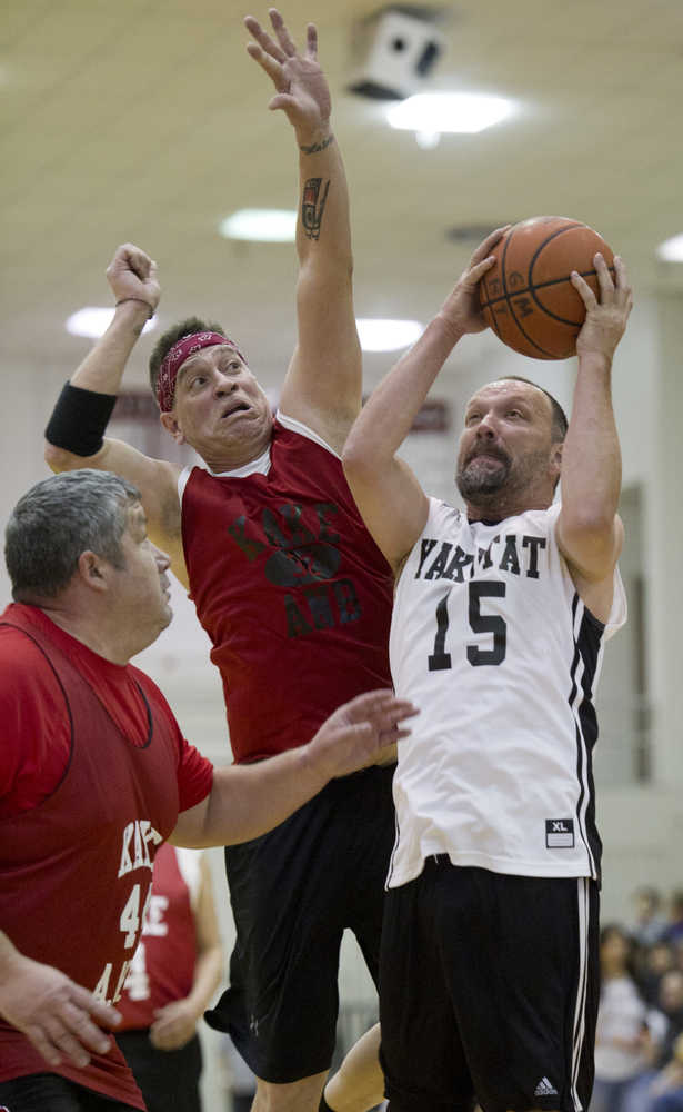 Yakutat's Greg Indreland attempts to shoot against Kake's Nick Davis, center, and Robert Jackson during their "Masters" bracket game in the 2016 Juneau Lions Club 70th Gold Medal Basketball Tournament at Juneau-Douglas High School on Monday.