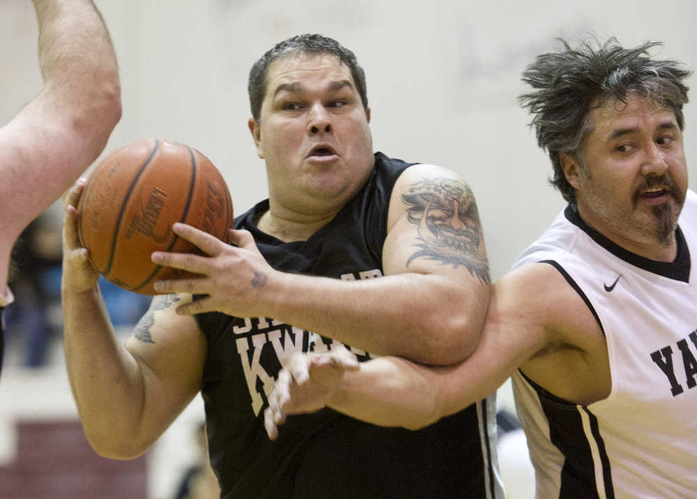 Klukwan's Tim Wilson, left, grabs a loose ball in front of Yakutat's Gary Klushkan during their Masters bracket game in the 2016 Juneau Lions Club 70th Gold Medal Basketball Tournament at Juneau-Douglas High School on Wednesday.