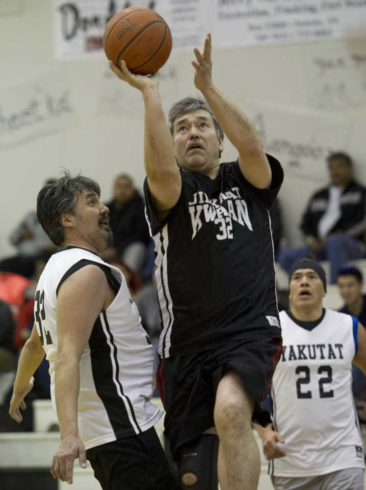 Klukwan's Dan Hotch drives to the basket between Yakutat's Gary Klushkan, left, and Sam Demmert during their Masters bracket game in the 2016 Juneau Lions Club 70th Gold Medal Basketball Tournament at Juneau-Douglas High School on Wednesday.