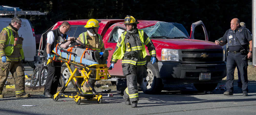 Capital City Fire/Rescue personnel wheel a man to a waiting ambulance at the scene of a two-car accident near the Egan Drive and Mendenhall Loop Road intersection in the Mendenhall Valley Thursday morning. Two people were treated at Bartlett Regional Hospital for minor injuries.