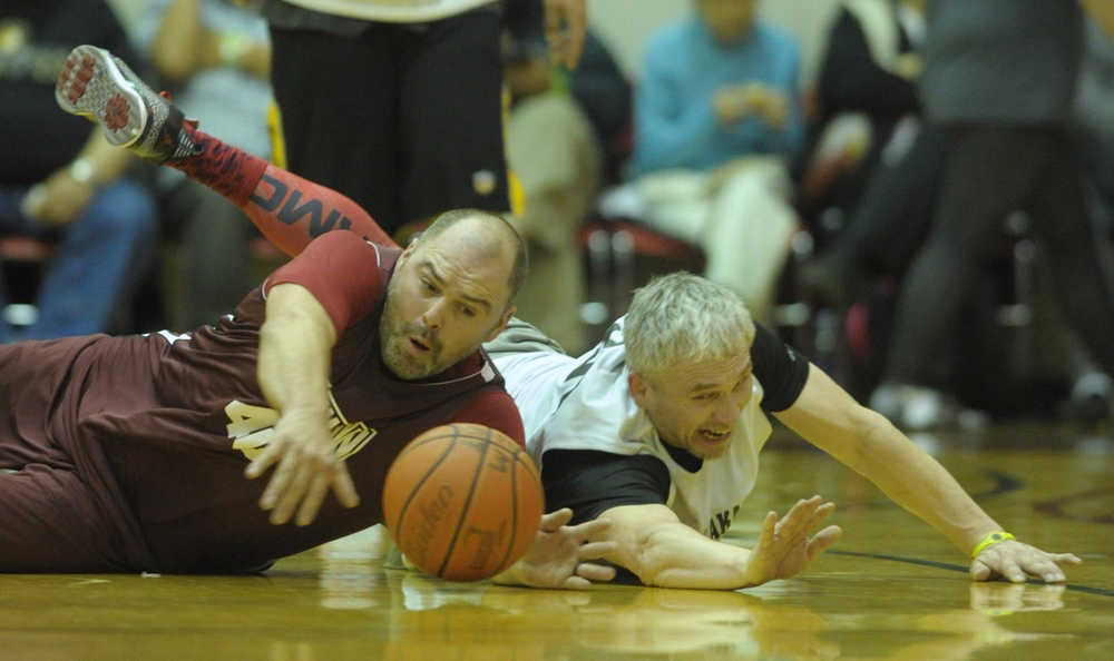 Klukwan's Stuart DeWitt, left, dives for the ball against Metlakatla's Archie Dundas on Saturday during the C Bracket championship of the 70th annual Gold Medal Basketball Tournament at Juneau-Douglas High School.