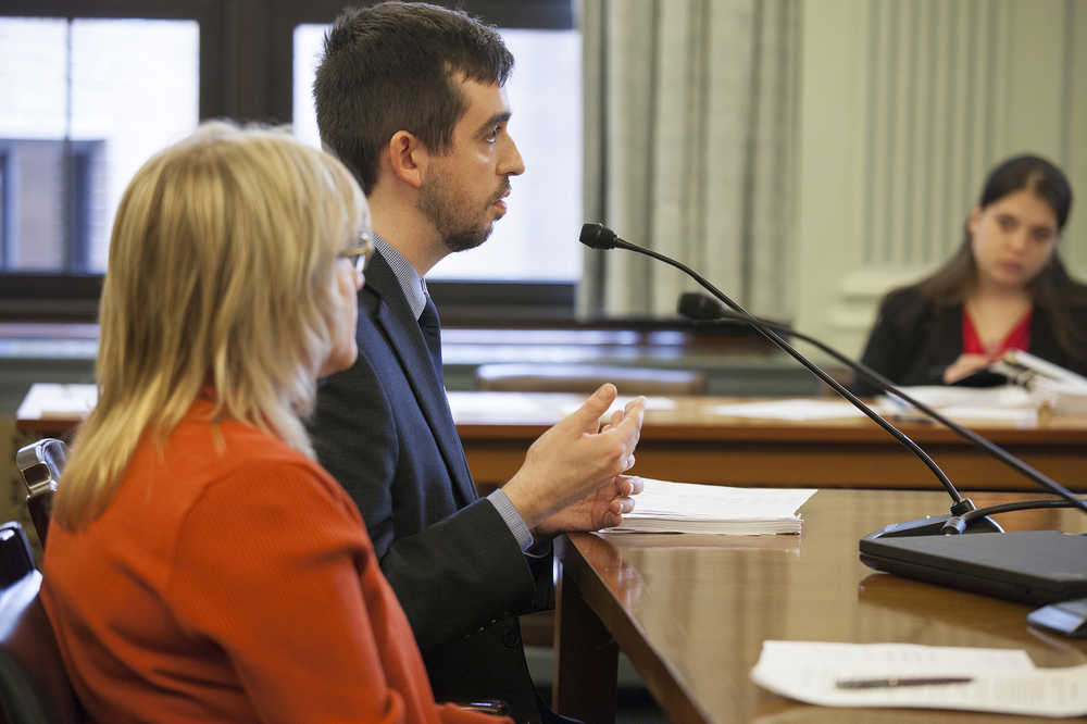 Jordan Shilling, aide to Sen. John Coghill, talks about the meaning of justice during a hearing on an omnibus crime bill designed to overhaul the state's criminal justice system, Tuesday, March 29, 2016, in Juneau, Alaska.  The bill is being heard by Senate Finance committee which discussed reinvestment options for the money that could be saved by reducing the state's prison population. At left is Brenda Stanfill, of Fairbanks, Alaska, an advocate for victim's rights on the Alaska's Criminal Justice Commission. (AP Photo/Rashah McChesney)