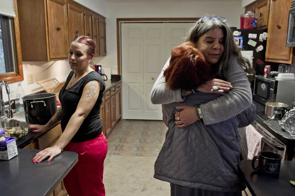 House manager Julee Douglas gives a former resident a hug as current resident Andrea Robinson, left, prepares a group dinner at Haven House on Tuesday. Haven House is celebrating its one-year anniversary as a transitional home for recently released female prisoners and women coming out of substance abuse or mental health treatment.