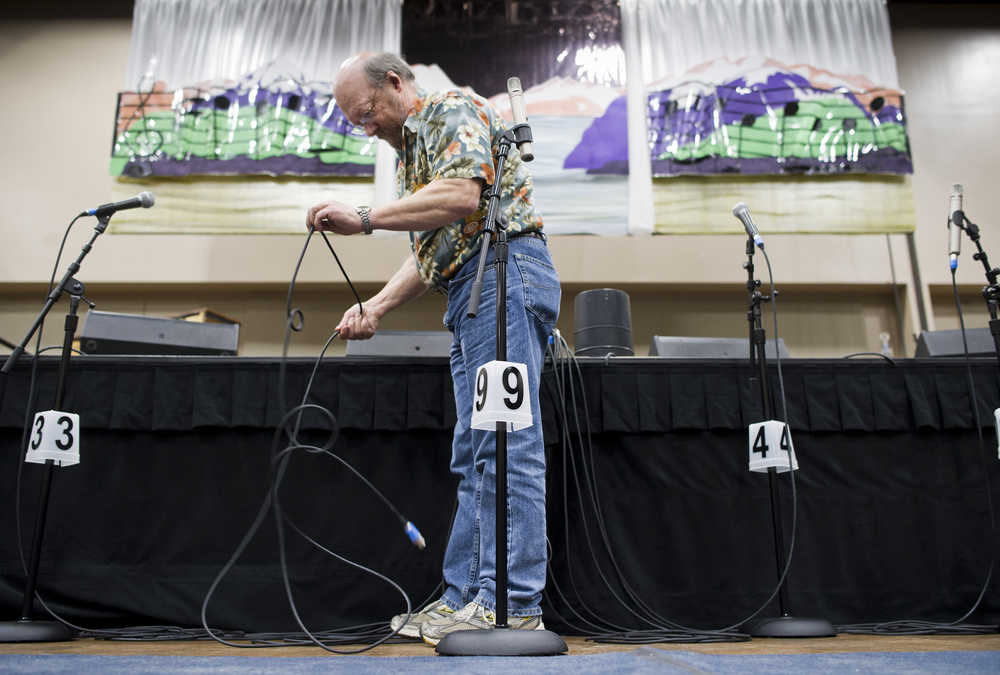 Sound engineer Rick Miller of Anchorage untangles microphone cords in front of the Alaska Folk Festival stage at Centennial Hall on Monday. The week-long free music festival includes nightly performances, dances starting Thursday night and weekend workshops.