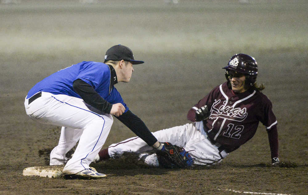 Ketchikan High School's Kody Malouf (12) slides into the glove of Thunder Mountain's Philip Wall on Friday, April 8, 2016, during the Kings' 7-5 win against the Falcons at Norman Walker Field.