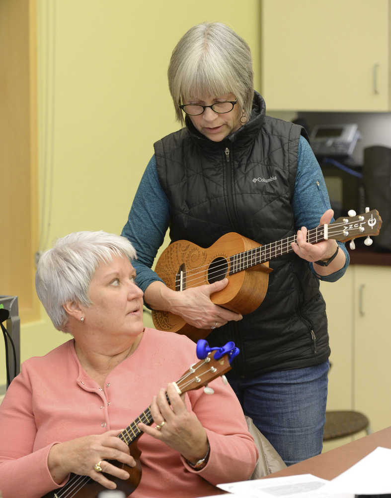 In this Feb. 10 photo ukulele instructor Kathy Paulson, right, shows Sally Potter a chord fingering at the public library in Ketchikan.