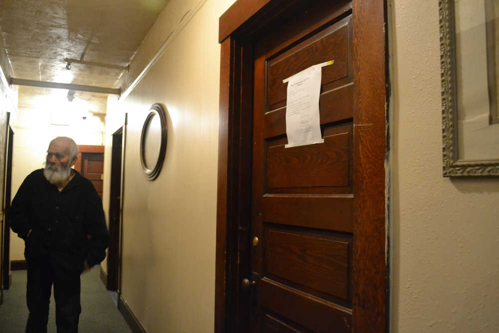 A Bergmann Hotel resident walks down the hall past an eviction notice posted on a door.