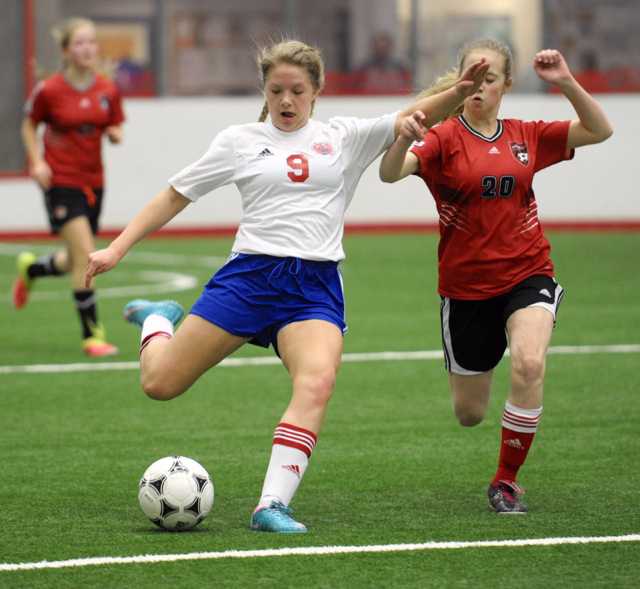 Makenna Graham, left, drive the ball against her Whitehorse opponent during Juneau Soccer Club's exchange tournament in Whitehorse, Yukon, at the Canada Games Centre in Whitehorse on Friday. Ninety-six players on 10 teams are playing through Sunday.