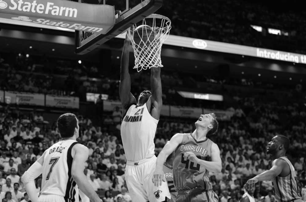 Miami Heat center Hassan Whiteside (21) dunks over Charlotte Hornets center Cody Zeller (40) and guard Kemba Walker, right, during the second half of Game 1 of a first-round NBA basketball playoff series, Sunday, April 17, 2016, in Miami. The Heat defeated the Hornets 123-91. (AP Photo/Lynne Sladky)