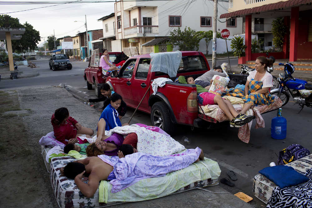Families wake up after sleeping outside their collapsed homes that were destroyed by an earthquake in Manta, Ecuador, Tuesday, April 19, 2016. The strongest earthquake to hit Ecuador in decades flattened buildings and buckled highways along its Pacific coast, sending the Andean nation into a state of emergency. (AP Photo/Rodrigo Abd)