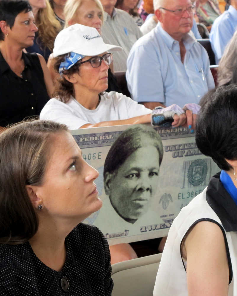 FILE - In this Monday, Aug. 31, 2015, file photo, a woman holds a sign supporting Harriet Tubman for the $20 bill during a town hall meeting at the Women's Rights National Historical Park in Seneca Falls, N.Y. A Treasury official said Wednesday, April 20, 2016, that Secretary Jacob Lew has decided to put Harriet Tubman on the $20 bill, making her the first woman on U.S. paper currency in 100 years. (AP Photo/Carolyn Thompson, File)