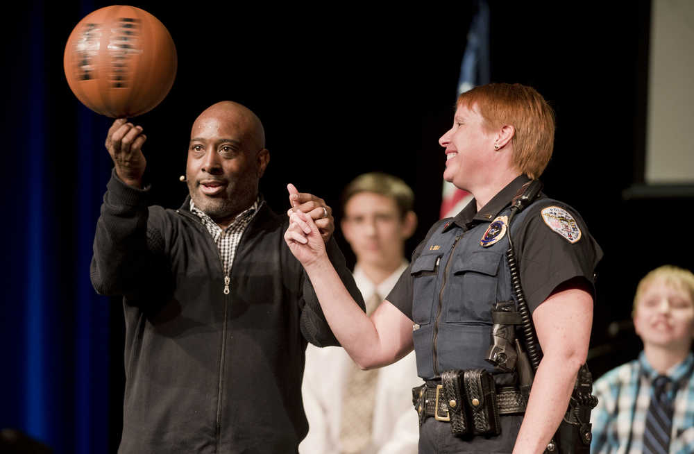 Guest speaker Melvin Adams prepares to spin a basketball on Juneau Police Department Lt. Kris Sell's finger during the Pillars of America program at Centennial Hall on Wednesday. Adams is the first of three speakers in the weekly series hosted by the Juneau Glacier Valley Rotary Club. Tiana Tozer is next week's speaker followed by Warren Moon on May 4.