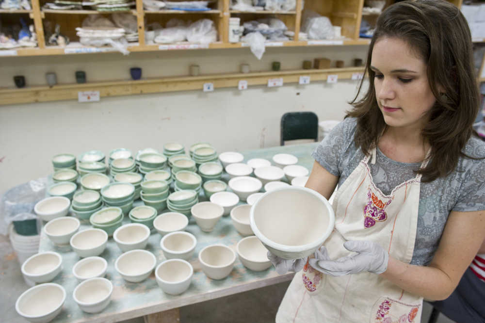 Mercedes Muñoz, ceramics studio manager at The Canvas, glazes ceramic bowls Tuesday for this weekend's fundraiser for the Glory Hole.