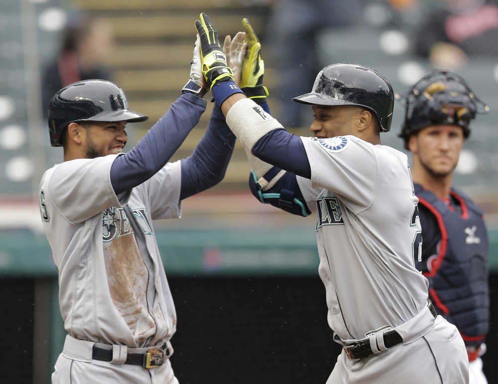 Seattle Mariners' Robinson Cano, right, and Luis Sardinas celebrate after Cano hit a three-run home run off Cleveland Indians relief pitcher Cody Allen in the tenth inning of a baseball game, Thursday, April 21, 2016, in Cleveland. Franklin Gutierrez and Sardinas scored on the play. The Mariners won 10-7 in ten innings. (AP Photo/Tony Dejak)