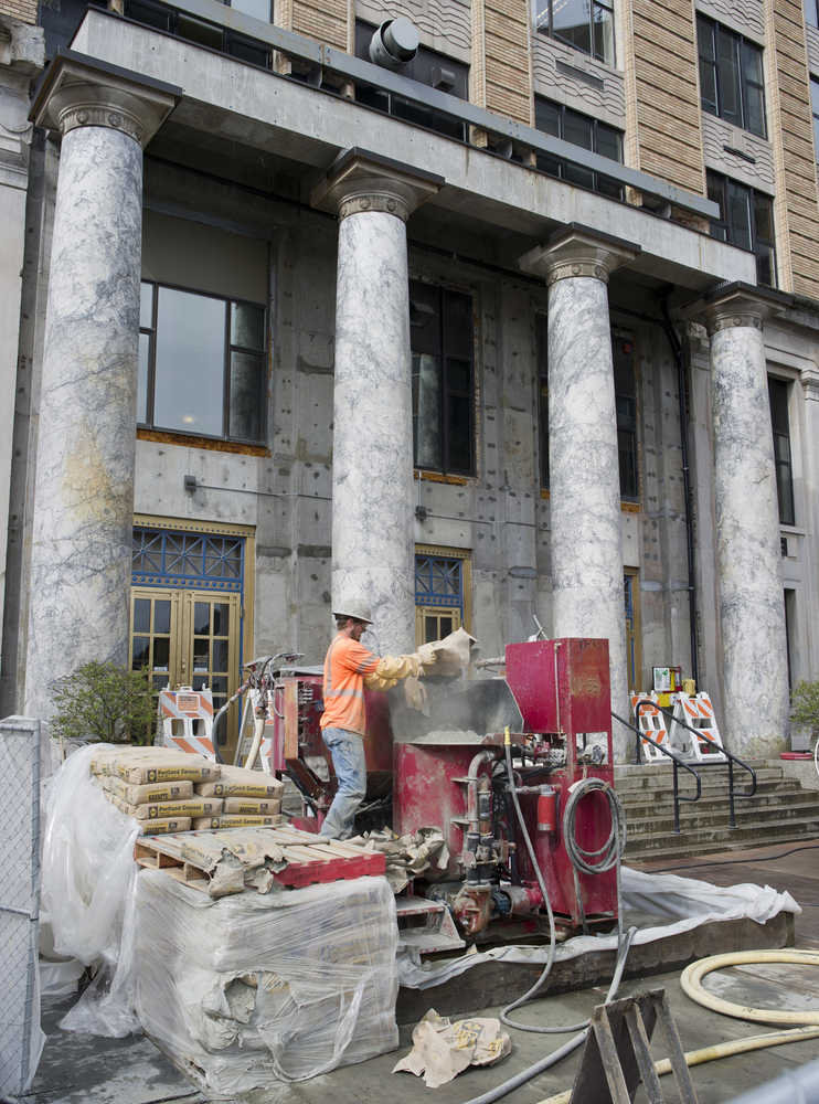 A Dawson Construction worker feeds a cement making machine as construction work ramps up at the Capitol on Monday.