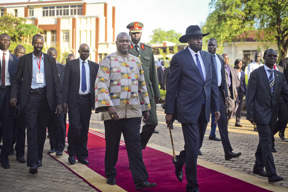 South Sudan's rebel leader and now Vice President Riek Machar, center-left, walks with President Salva Kiir, center-right, after being sworn in Tuesday at the presidential palace in the capital Juba, South Sudan.