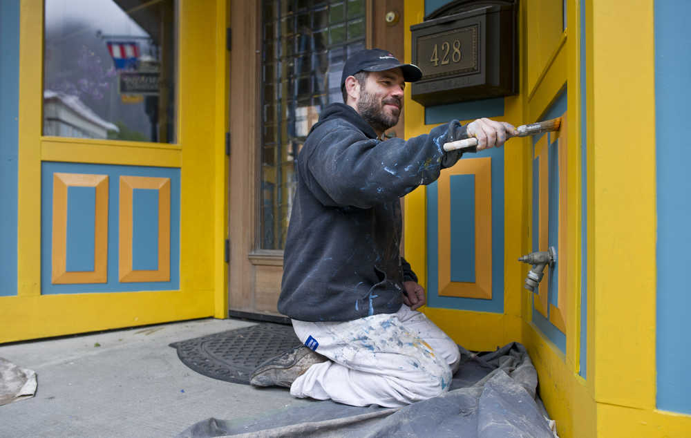 Woody Collins touches up the paint on the Effy Jewelers on South Franklin Street on Tuesday. The first cruise ship of the season arrives on Saturday, April 30.