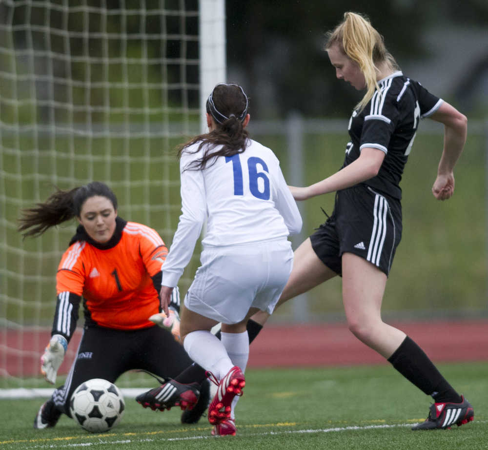 Thunder Mountain goalie Tianna Huber, left, and teammate Sienna Hanna try to stop Juneau-Douglas' Maddie McKeown from scoring during their game at Thunder Mountain HIgh School on Tuesday. The shot went wide but Juneau-Douglas went on to win the game 5-0.