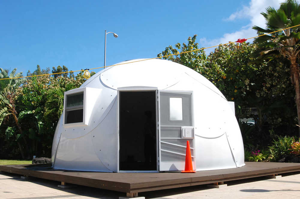 In this Friday, April 22, 2016 photo, a dome-shaped shelter is shown at the First Assembly of God church in Honolulu. The church is looking into an unexpected solution to state's homeless crisis: they're planning to erect Alaska-made igloos to house homeless families. The snow-inspired dome-shape structures would appear at first glance to be a misfit among the island state's palm trees and sandy beaches, but their bright fiberglass exterior reflects the sun, shading those inside. (AP Photo/Caleb Jones)