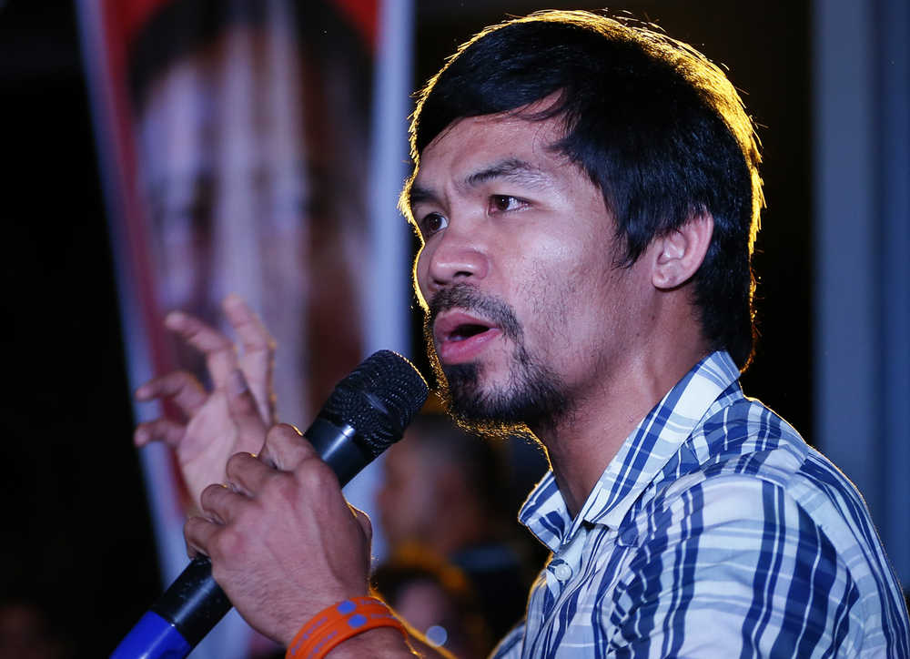Boxing star Manny Pacquiao addresses supporters as he campaigns for a seat in the Philippine Senate, on Thursday, April 28, 2016 at San Pablo city, Laguna province south of Manila, Philippines. Pacquiao had few visible security escorts as he campaigned in Laguna province, shaking hands and allowing mobs of villagers to take selfies with him despite a reported militant plot to kidnap him. (AP Photo/Bullit Marquez)