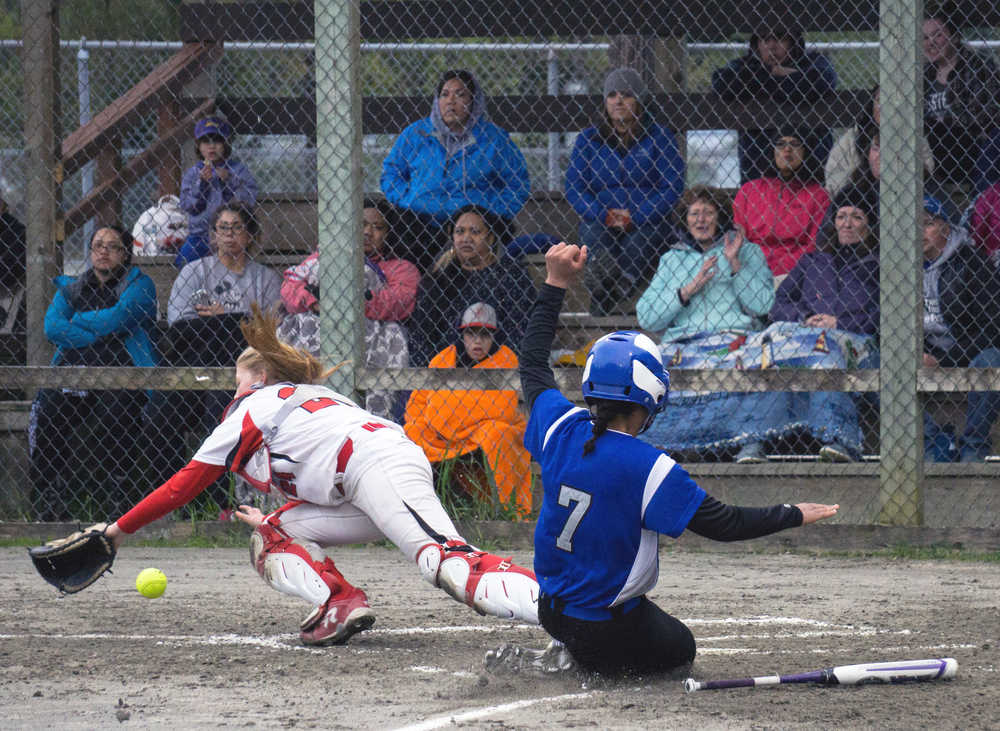 Thunder Mountain's Sarah Jenkins slides into home plate as Juneau-Douglas catcher Morgan Balovich reaches for the ball on Wednesday.