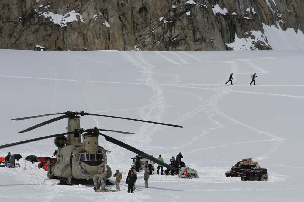 This photo taken Sunday, April 24, 2016, on the Kahiltna Glacier in Alaska, shows Army soldiers unloading a Chinook helicopter that landed on the glacier near Denali. The U.S. Army helped set up base camp on North America's tallest mountain. Three Chinook helicopters the size of city buses took supplies like food, communication equipment and fuel to the base camp at the 7,200-foot level of Denali.  (AP Photo/Mark Thiessen)