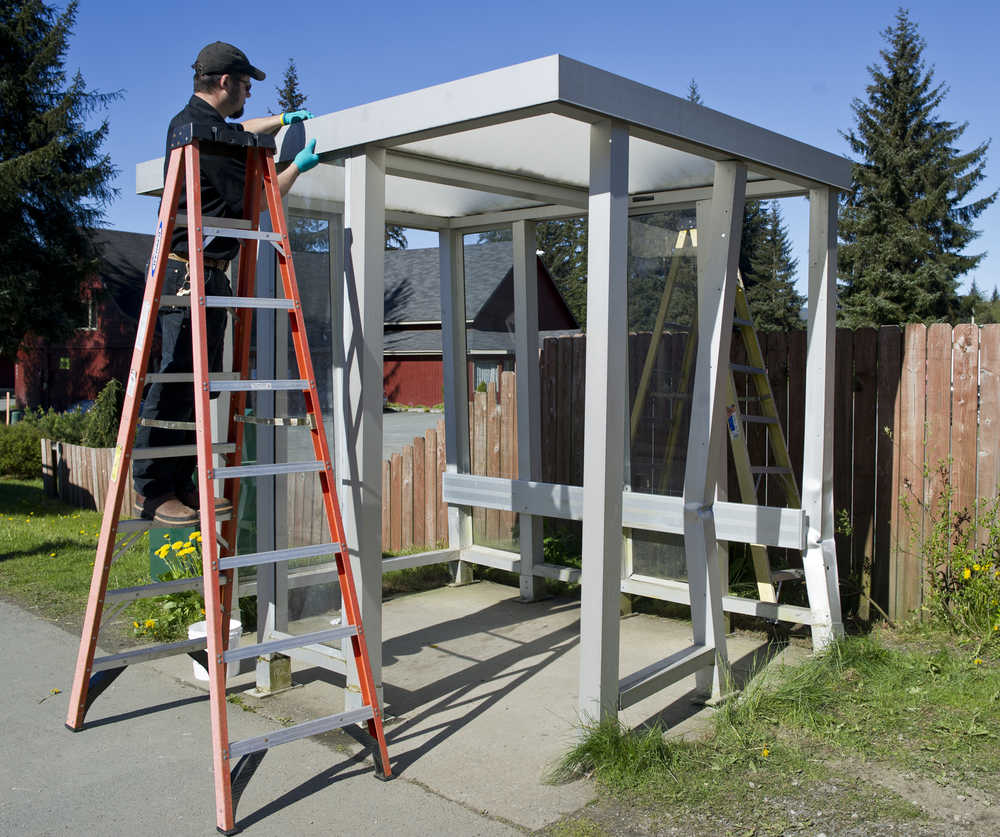 Michael Coleman of the city's maintenance department, works on a bus shelter damaged by a vehicle on Mendenhall Loop Road in front of the Glacier Valley Baptist Church on Wednesday.