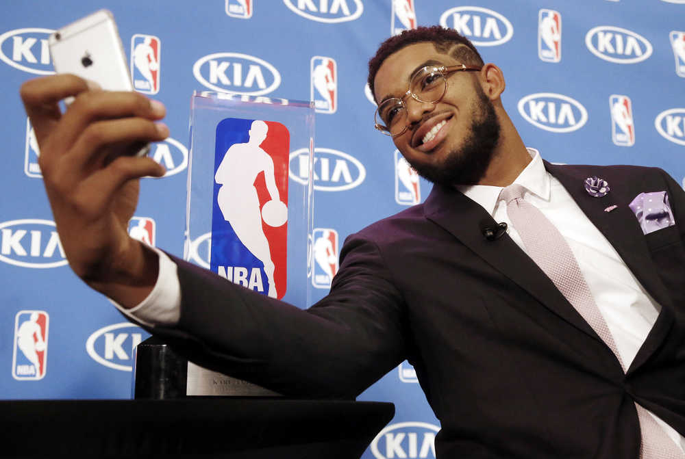 Minnesota Timberwolves' Karl-Anthony Towns takes a selfie with his NBA Rookie of the Year trophy next to him after a news conference announcing his selection Monday, May 16, 2016, in Minneapolis. Towns was the number one overall pick in the 2015 NBA draft. (AP Photo/Jim Mone)