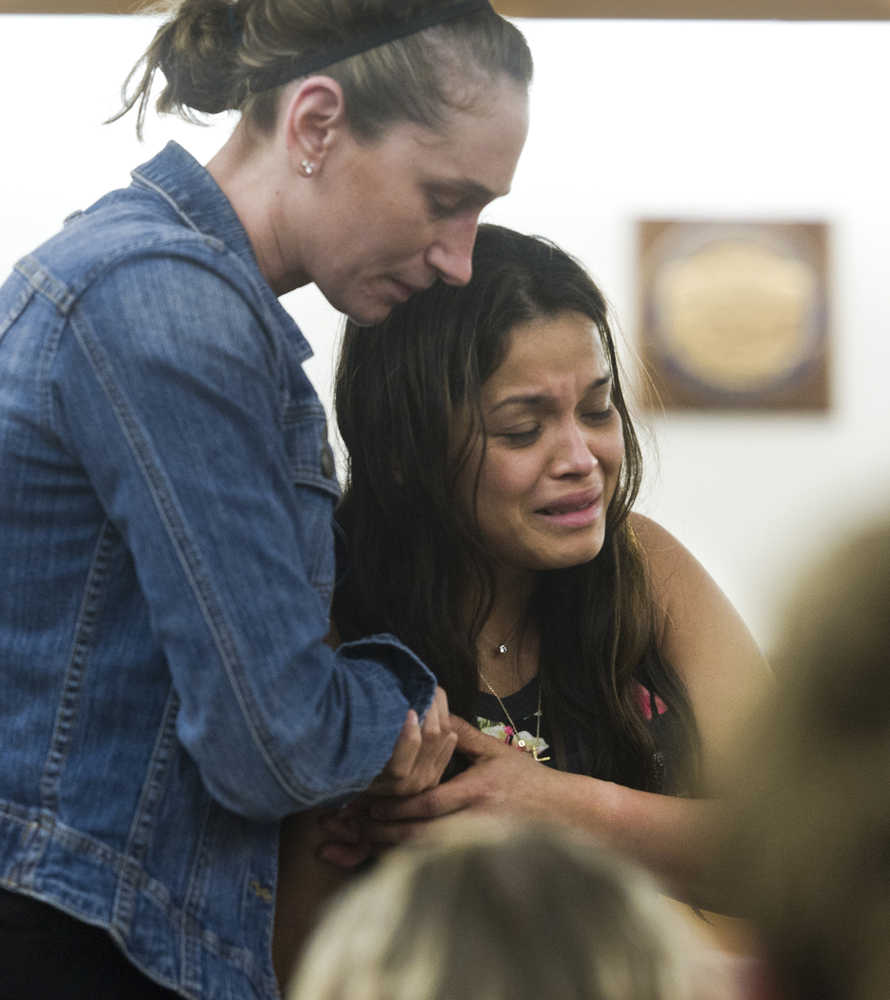 Maria Rosales, whose husband Duilio Antonio "Tony" Rosales, 34, was fatally shot Sunday night at a remote Excursion Inlet cabin, cries as she is escorted out of Juneau District Court Tuesday by Mattie Rielly-Bixby, a paralegal for the Juneau District Attorney's Office. Mark De Simone was charged with first- and second-degree murder in connection to Rosales' death and is behind held in custody in lieu of $500,000 bail.