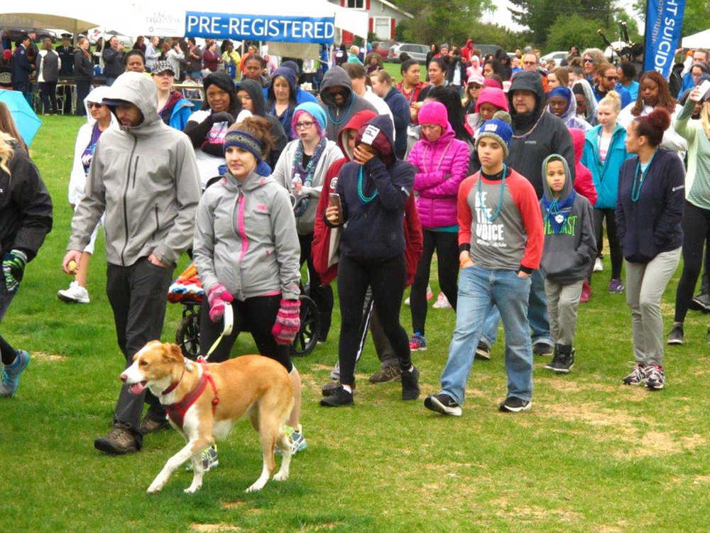People, some with their dogs, begin a 3 mile suicide-prevention walk Saturday in Anchorage. More than 700 Alaskans took part in the event to raise awareness about suicide.