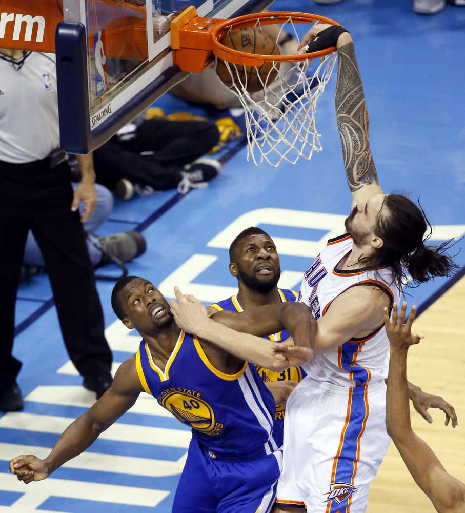 Oklahoma City Thunder center Steven Adams (12) dunks over Golden State Warriors forward Harrison Barnes (40) and center Festus Ezeli (31) during the second half in Game 4 of the NBA basketball Western Conference finals in Oklahoma City, Tuesday, May 24, 2016. (AP Photo/Sue Ogrocki)