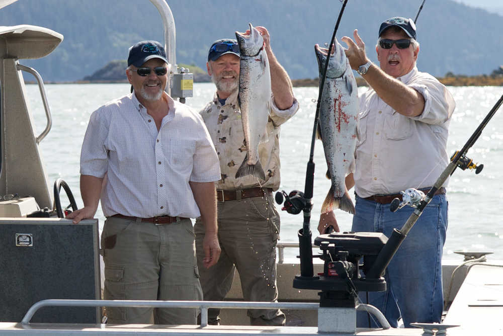 Kurt Henning, Bill Gissel and Craig Loken show a couple coho salmon they caught near North Island on the first day of the 69th annual Golden North Salmon Derby.