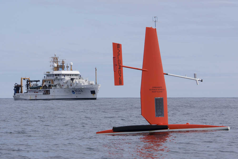 In this April 2015 photo released by NOAA Fisheries, a Saildrone, a 20-foot sailing vessel research platform developed by California-based Saildrone Inc., is tested in the Bering Sea. The NOAAresearch vessel Oscar Dyson is in the background. Two of the unmanned sailing vessels were launched May 24 from Dutch Harbor for marine mammal, fish and oceanographic research in the Bering Sea by federal and private researchers.