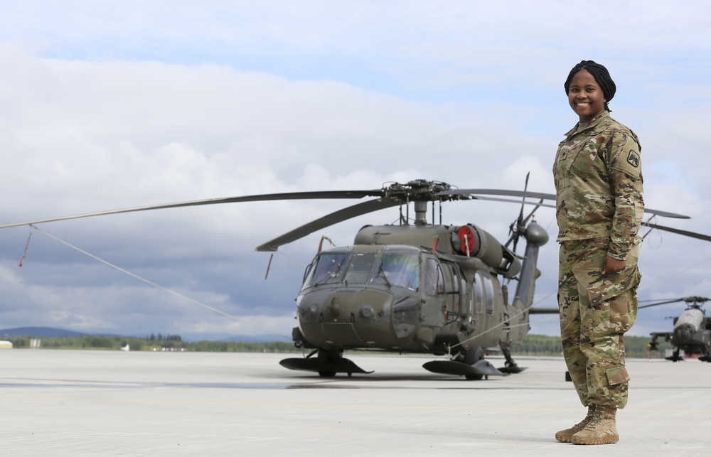 ADVANCE FOR WEEKEND JUNE 4-5 2016 AND THEREAFTER - In this May 26, 2016 photo, Spc. Brittany Cobb-Lyttle stands in front of a Black Hawk helicopter on Ladd Army Airfield at Fort Wainwright in Fairbanks, Alaska. (Erin Corneliussen/Fairbanks Daily News-Miner via AP)