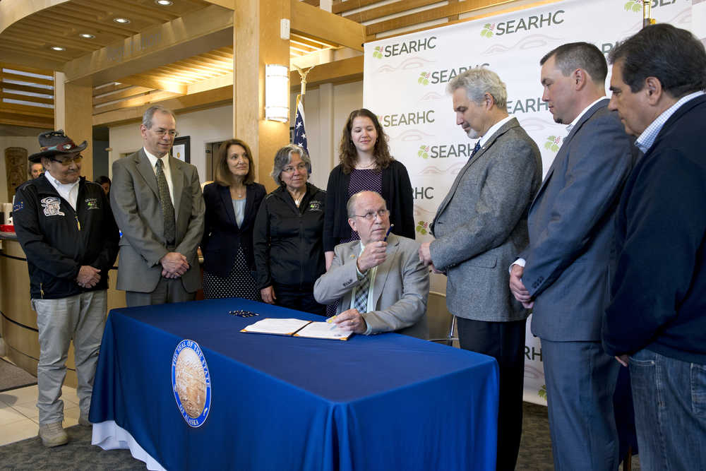Gov. Bill Walker hands Sen. Pete Kelly, R-Fairbanks, the pen he used to sign Senate Bill 74 into law at the  SouthEast Alaska Regional Health Consortium's Ethel Lund Medical Center on Tuesday. The bill is expected to save the state more than $365 million in the first six years in the state's Medicaid program. Also appearing from left: John Morris, SEARHC boardmember, Jon Sherwood, Deputy Commissioner of the Department of Health and Social Services, Sana Efird, Assistant Commissioner of the Department of Health and Social Services, Kimberley Strong, Chairman of the Board for SEARHC, Heather Shadduck, staff to Sen.Pete Kelly, Sen. Kelly, Charles Clement, President/CEO of SEARHC, and Carlton Smith, trustee of the Mental Health Trust.