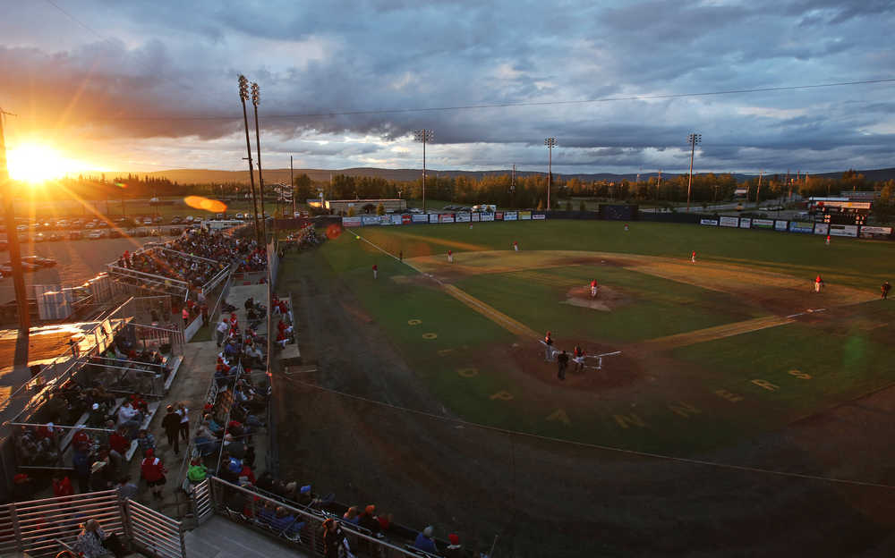 The sun peeks through the clouds above the horizon just before midnight during the 111th Midnight Sun Baseball Game between the Alaska Goldpanners and the Peninsula Oilers Tuesday night, June 21, 2016 at Growden Memorial Park in Fairbanks, Alaska. (Eric Engman/Fairbanks Daily News-Miner via AP) MANDATORY CREDIT