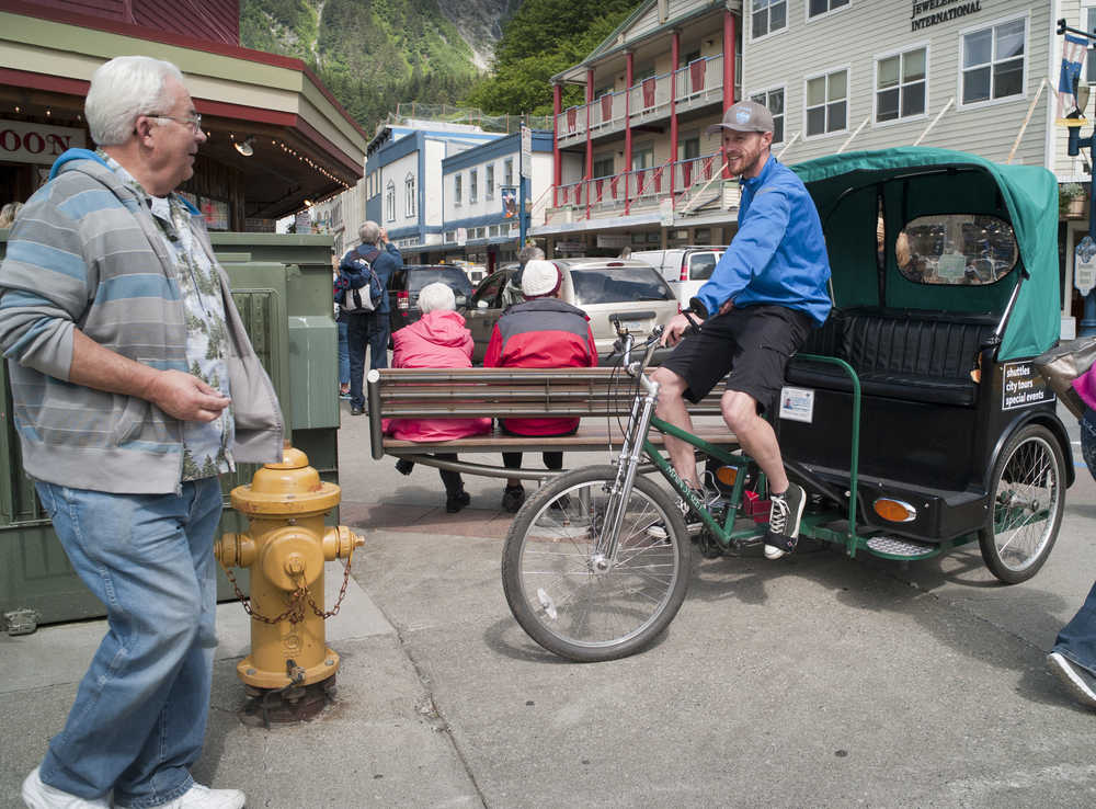 Kristopher McClure of Alaska Pedicab offers his services in front of the Red Dog Saloon in early June.